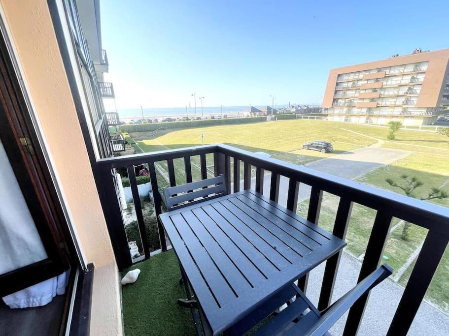 un banc sur un balcon avec vue sur un champ dans l'établissement T2 Vue Mer à 30m de la Plage, à Villers-sur-Mer