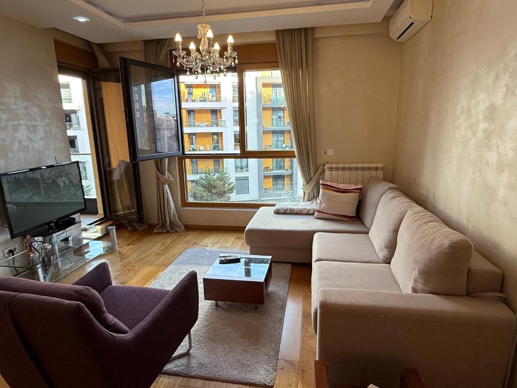 a living room with a couch and a tv at Central Garden modern 1 bedroom condominium complex in Belgrade
