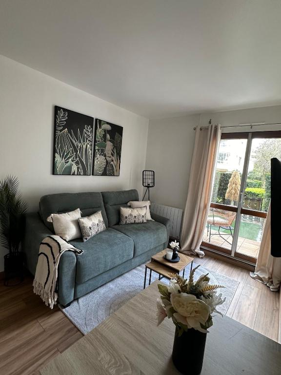un salon avec un canapé vert et une fenêtre dans l'établissement Premium & Cosy Studio - Paris à 20 mins - Châteaux de Versailles à 8 mins, à Le Chesnay