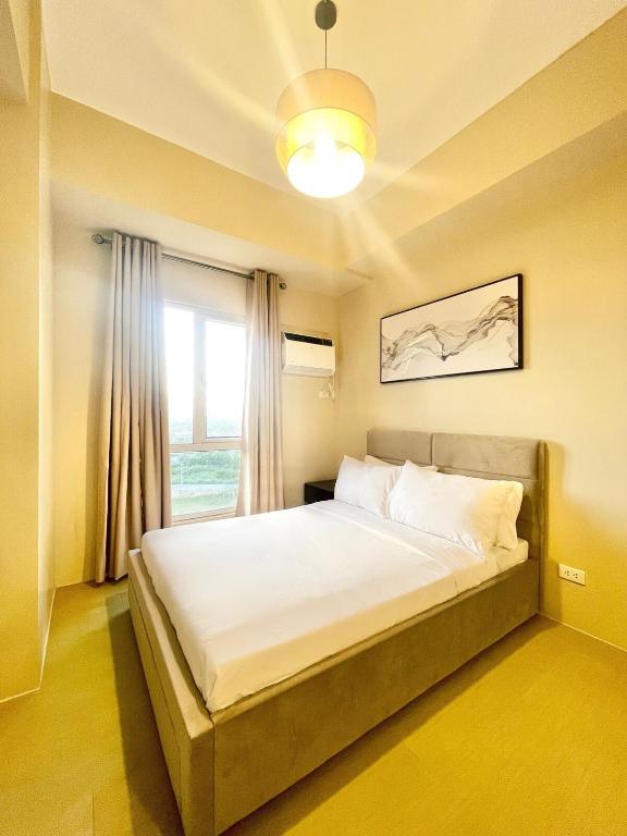 un letto grande in una stanza con una finestra di B3 Chic Sunset Studio Escape a Città di Iloilo