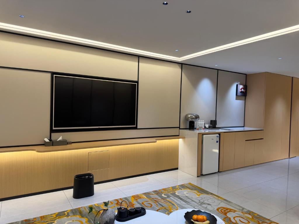 a living room with a large flat screen tv at Purple Stone High-End Designer Loft in Harbin
