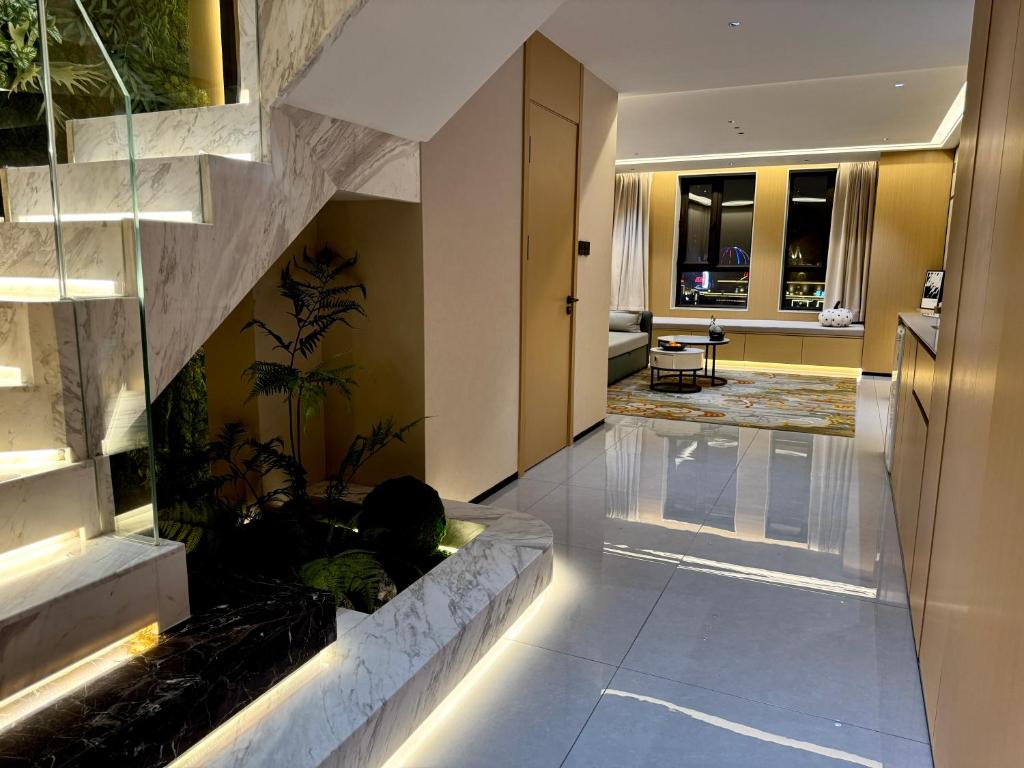 a lobby with a fish tank in the middle of a building at Purple Stone High-End Designer Loft in Harbin