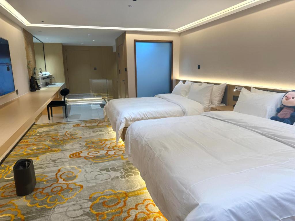 a hotel room with two beds and a desk at Purple Stone High-End Designer Loft in Harbin
