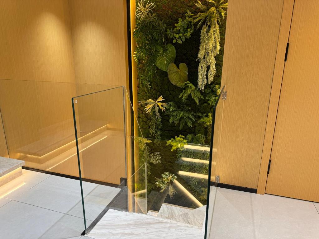 a glass door in a room with a plant at Purple Stone High-End Designer Loft in Harbin