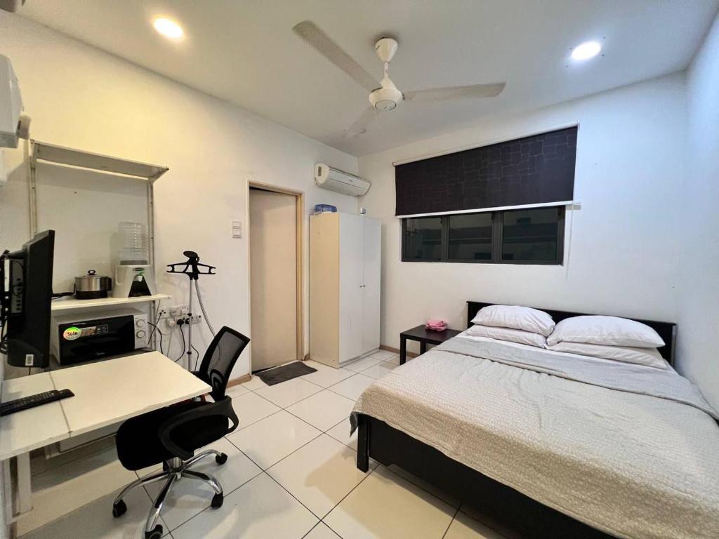 a bedroom with a bed and a desk and a computer at Vista Alam S Studio in Shah Alam