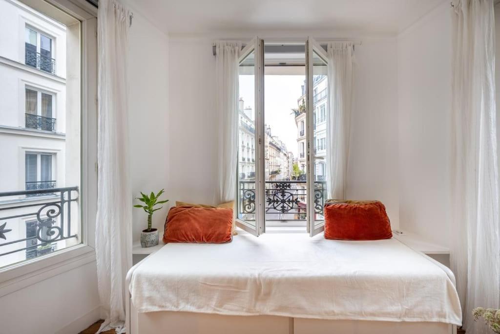a bedroom with a bed and a window at Cosy Apartment with 270 degrees view on Paris streets in Paris