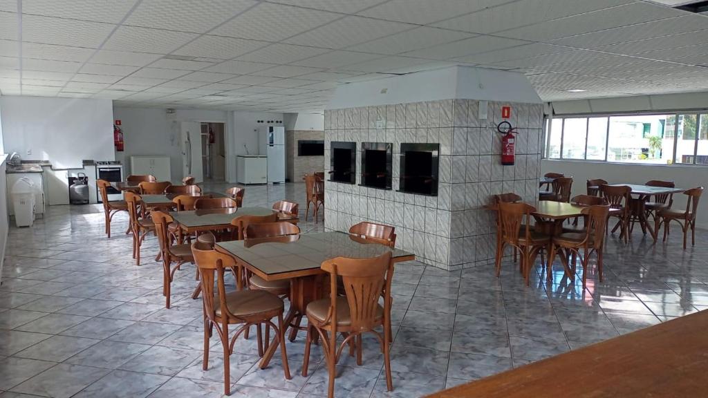 uma sala de jantar com mesas e cadeiras e uma lareira em APTO BEIRA MAR BALNEARIO CAMBORIU no Balneário Camboriú