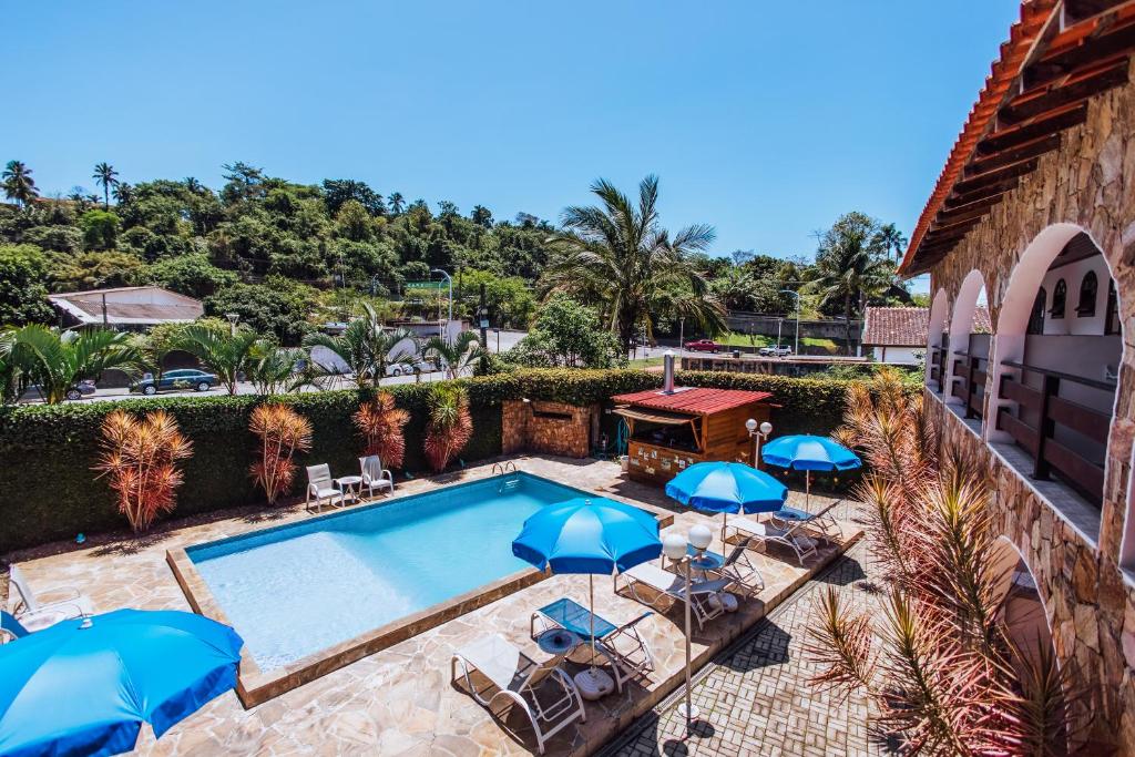 an overhead view of a swimming pool with umbrellas at VELINN Pousada Casa de Pedra Ilhabela in Ilhabela