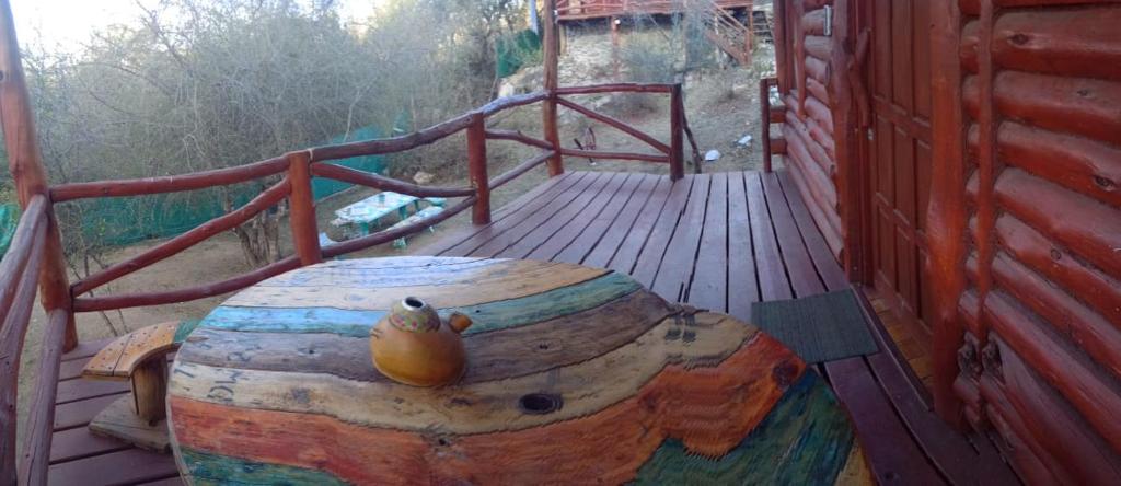 a wooden deck with a wooden table and a wooden railing at Cabañas - sierras de cordoba - Jose de la quintana #2 in José de la Quintana
