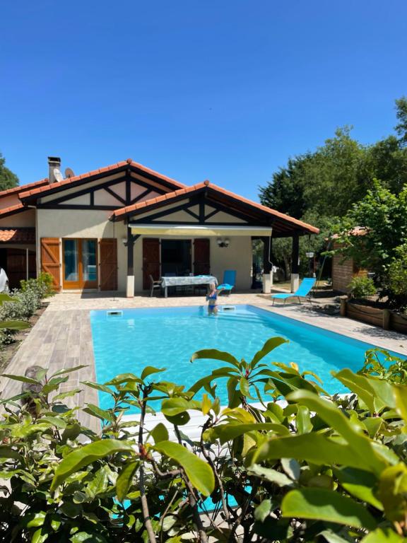 une maison avec une piscine devant dans l'établissement Pinsolle Côté Plage, à Soustons