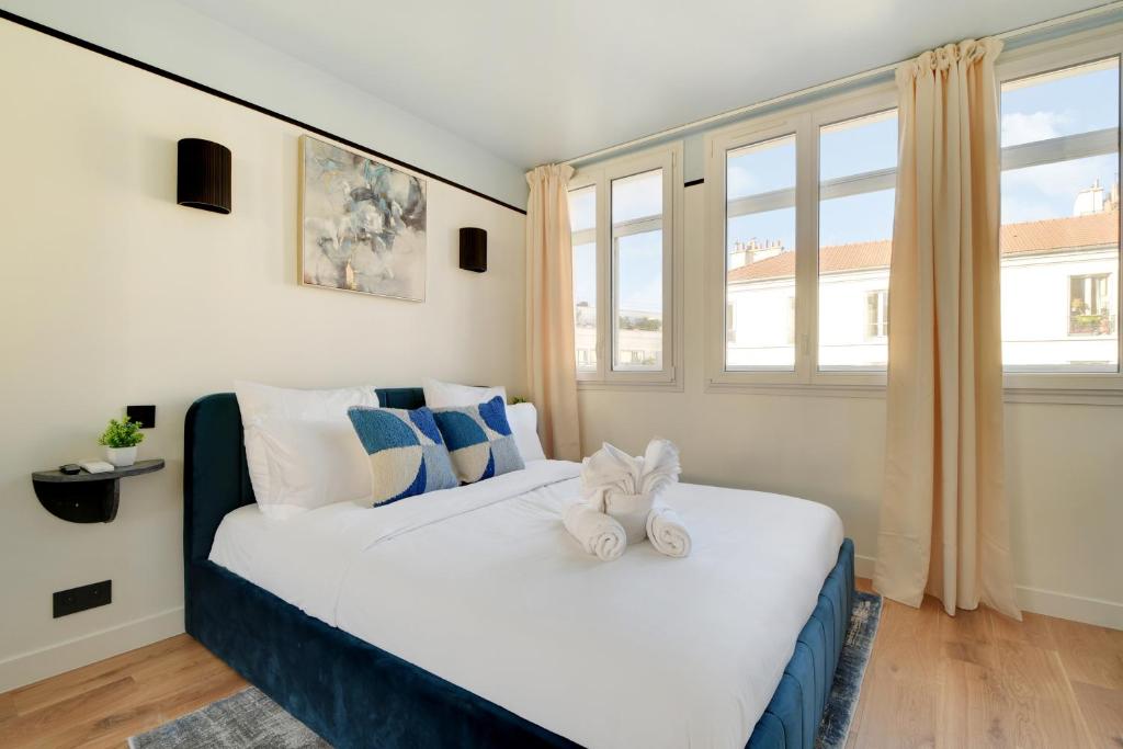 une chambre avec un lit avec un ours en peluche dessus dans l'établissement La Maison Bizot 53 T3 by ecoflats, à Paris