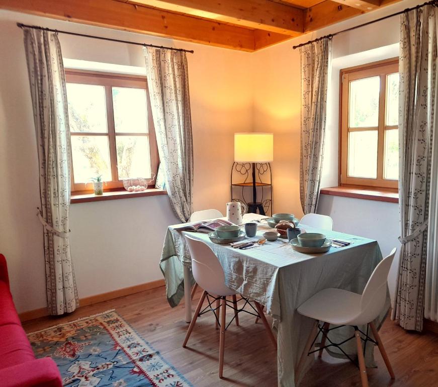 a dining room with a table and chairs and windows at Chalet Dolomiti Trentino in Sant’Orsola