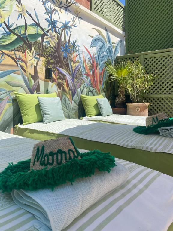 un gruppo di tre posti letto con piante sopra di Riad Dar Adal exclusivité 2 à 6 personnes petit déjeuner compris place jemaa El fna a Marrakech