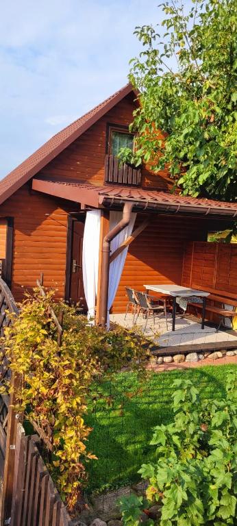 a house with a deck and a table on the porch at Domki na Chabrowej in Augustów
