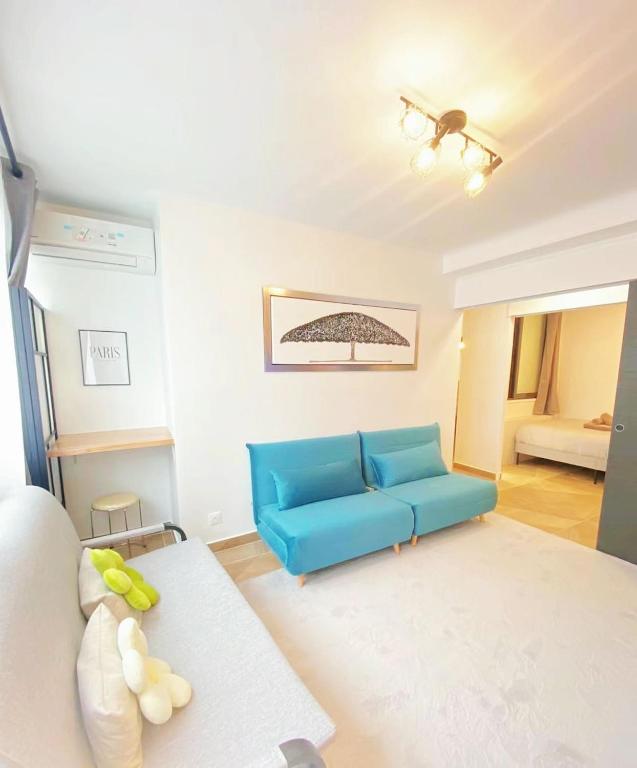 - un salon avec un canapé bleu et un lit dans l'établissement 3 BR With AC- Opéra Garnier -Galeries Lafayette, à Paris