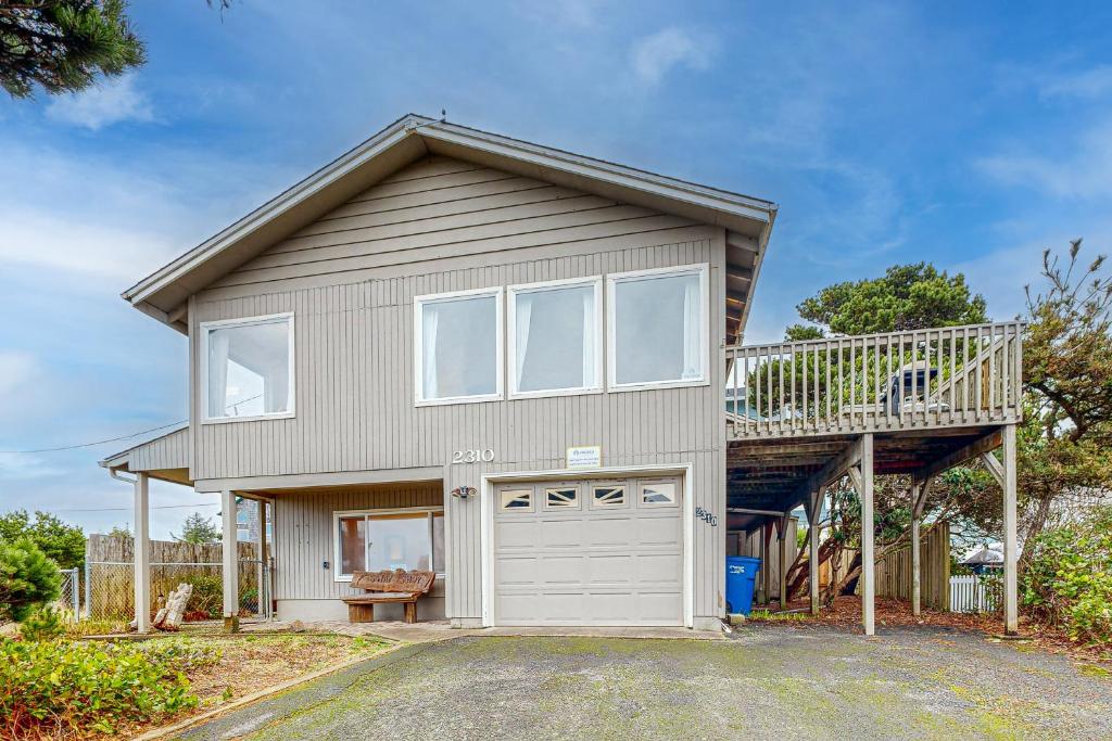 a house with a balcony and a garage at Let the Good Times Roll in Lincoln City