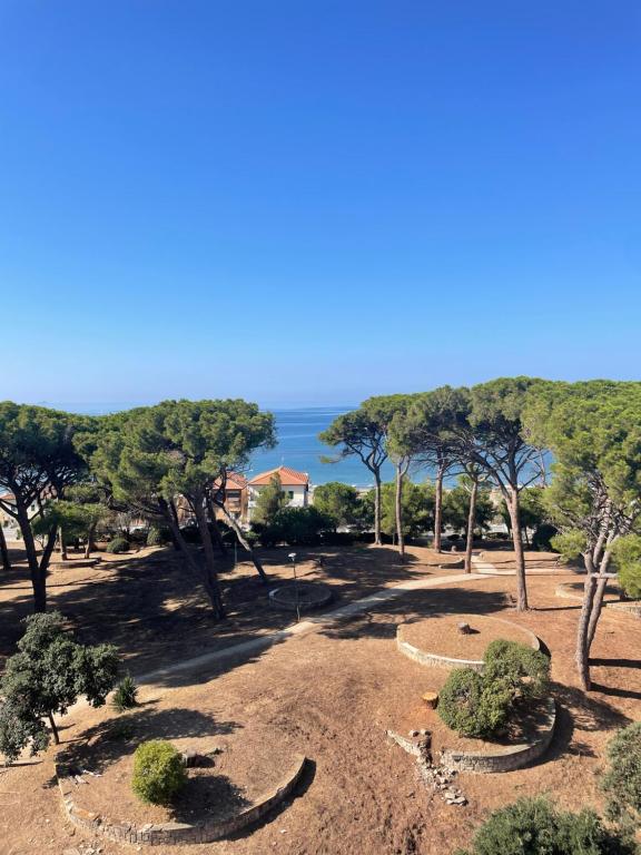 a park with trees and the ocean in the background at La Casina di Cice in Follonica