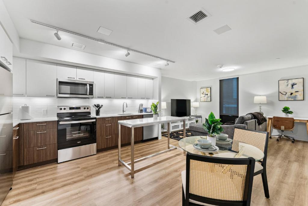 eine offene Küche und ein Wohnzimmer mit einem Tisch in der Unterkunft Furnished Luxury Apartment Next to Harvard Stadium in Boston