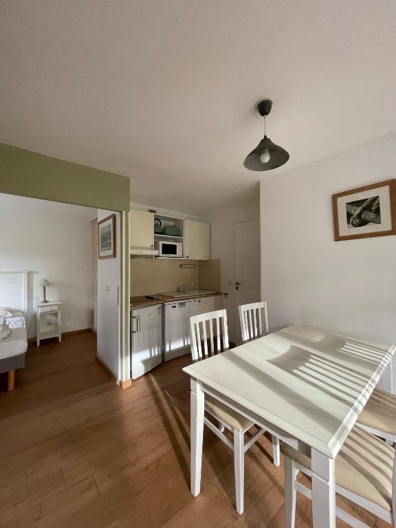 une cuisine et une salle à manger avec une table et des chaises dans l'établissement Appartement T3 au Bord du Lac, à Parentis-en-Born