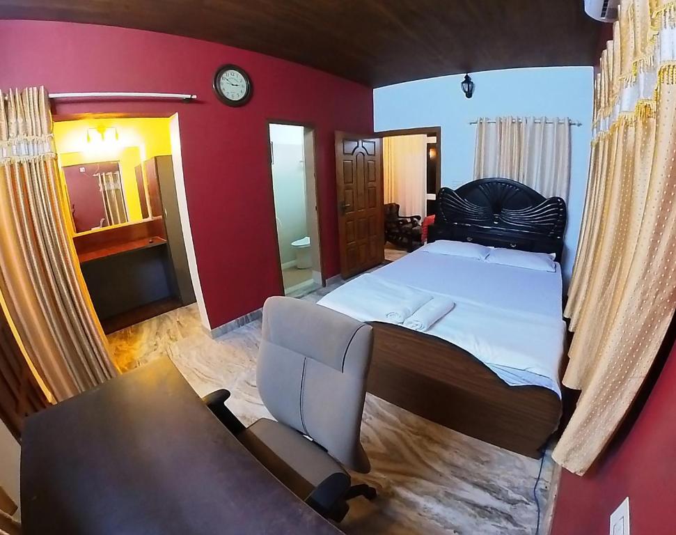 a bedroom with a bed and a couch and a chair at Homestay Rooms Muzhakkunnu Near Kannur International Airport in Iritti