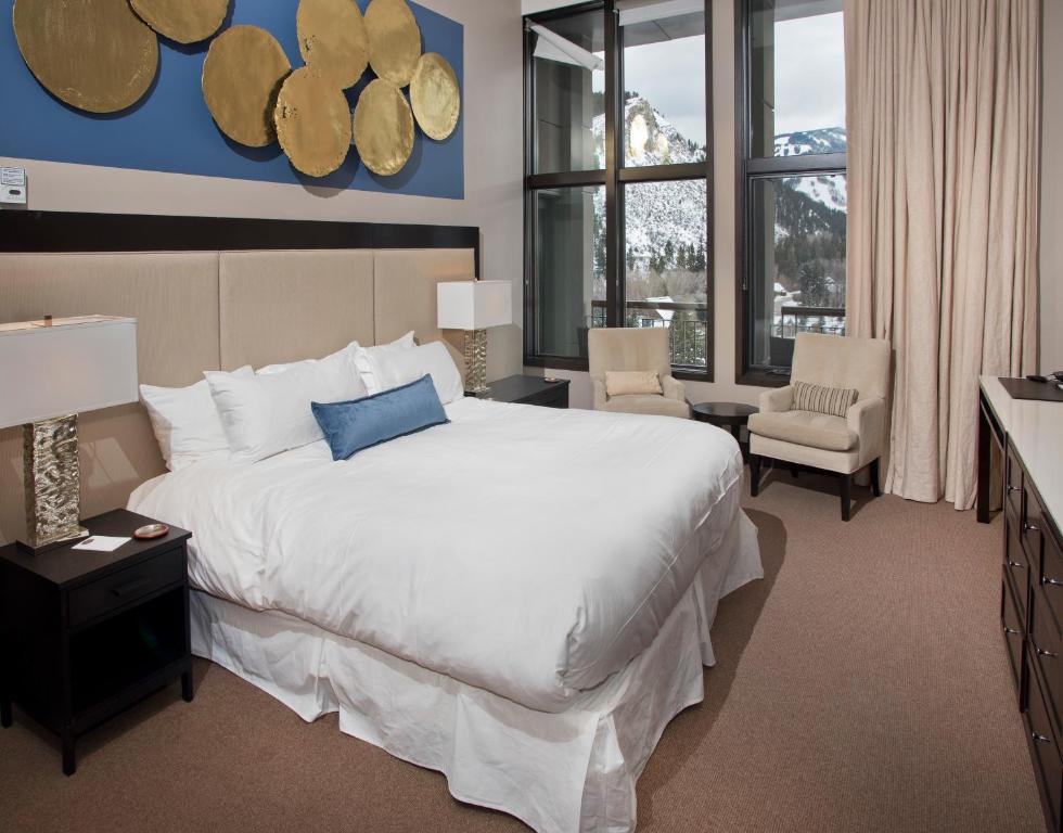 a large bedroom with a large white bed and windows at Westin Riverfront Penthouse in Beaver Creek