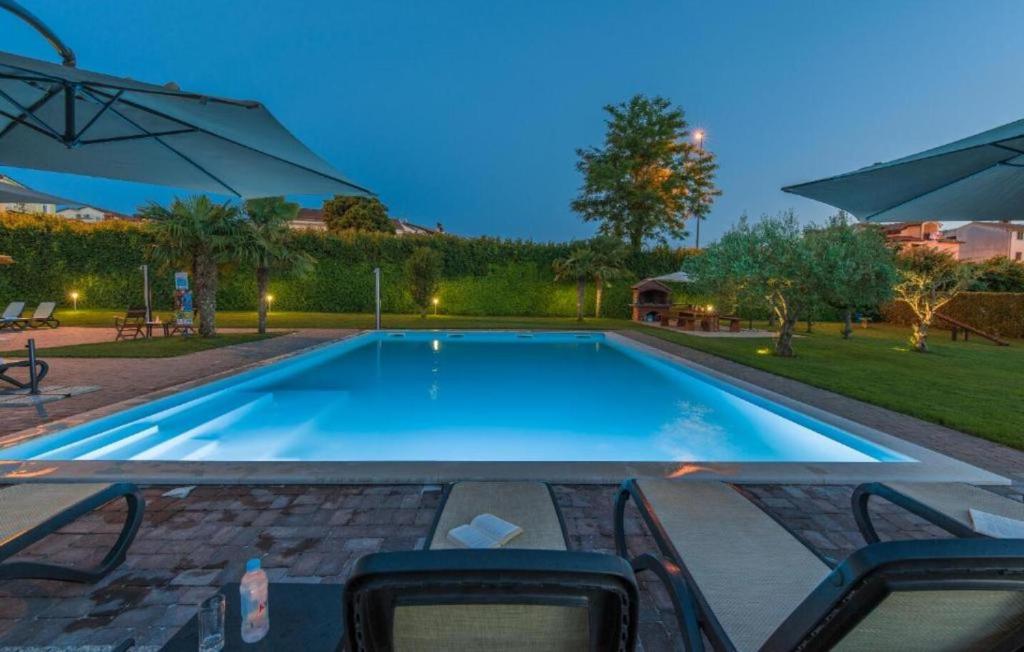 een zwembad in een achtertuin met een parasol bij MAJ - ANA - Luxury Family Apartments with Pool in Poreč