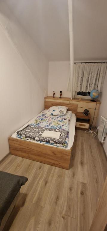 a bedroom with a bed and a wooden floor at Cudowny zakątek BIS in Bukwica