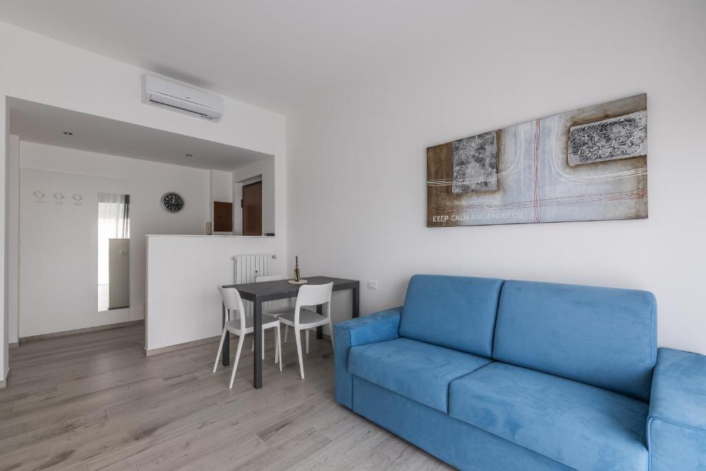 a living room with a blue couch and a table at Casa Teresa - Luminosa eleganza in Asti