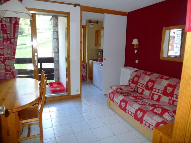 Cette chambre comprend un lit, une table et une cuisine. dans l'établissement Valmorel La Belle, skis aux pieds!, à Valmorel
