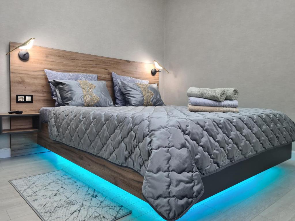 a bedroom with a large bed with a wooden headboard at Soul Park в шаге от Хан шатыр in Astana