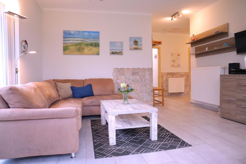 a living room with a couch and a table at Villa am Meer - Antje in Dorum-Neufeld