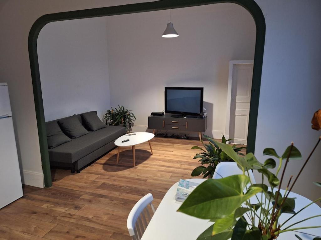 un salon avec un canapé et une télévision dans l'établissement Les racines de Montchapet, à Dijon