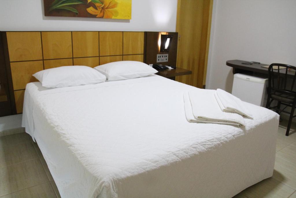 Postel nebo postele na pokoji v ubytování Dois Vizinhos Palace Hotel