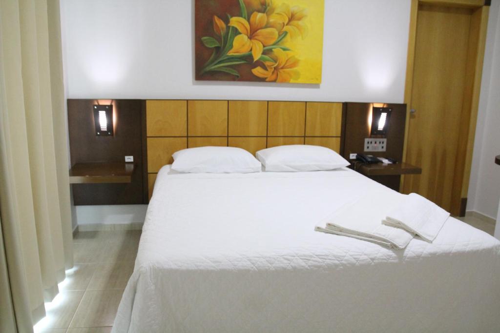 Postel nebo postele na pokoji v ubytování Dois Vizinhos Palace Hotel