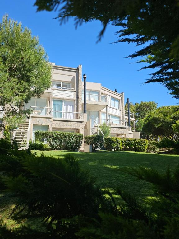 a large house with a lawn in front of it at Villa Agostina Apart & Spa in Mar de las Pampas