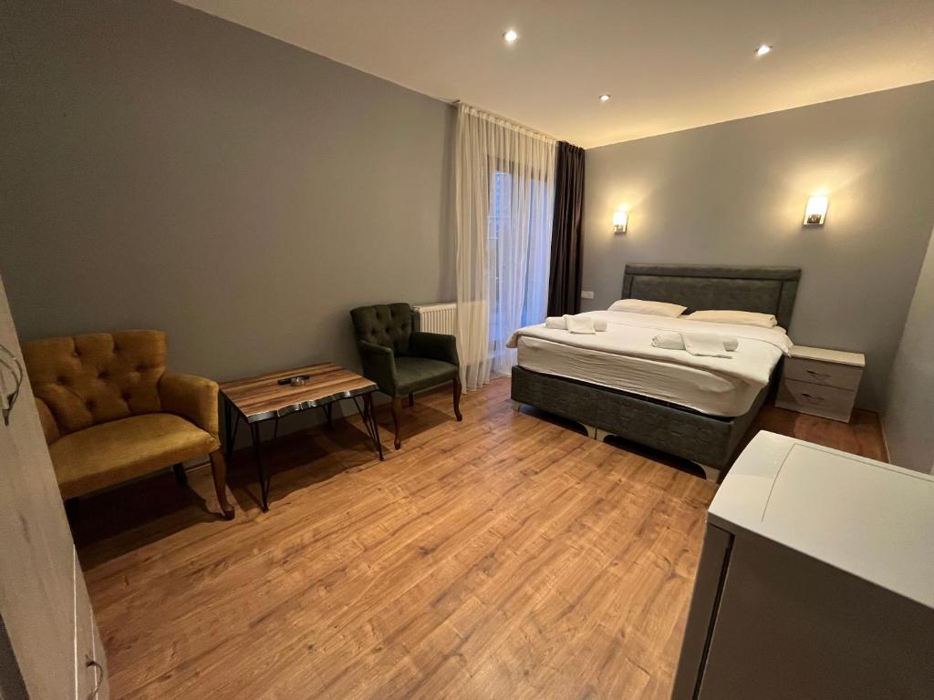 a bedroom with a bed and a chair and a table at Villasuit in Ankara