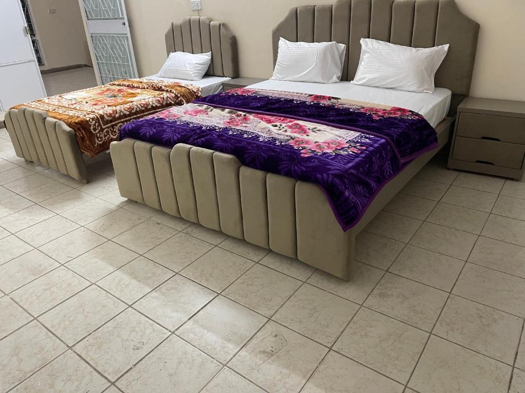 two beds sitting next to each other in a room at upper portion of a house in Islamabad