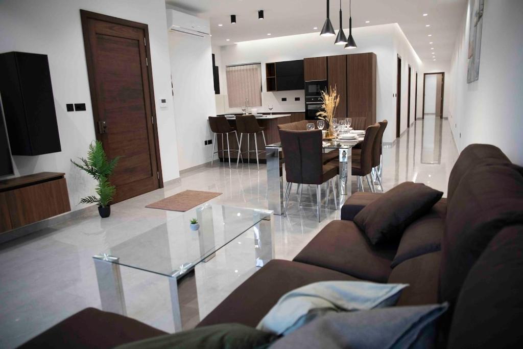 a living room and kitchen with a couch and a table at Flat 3, nearby Beaches & Countryside, with Terrace in Mġarr