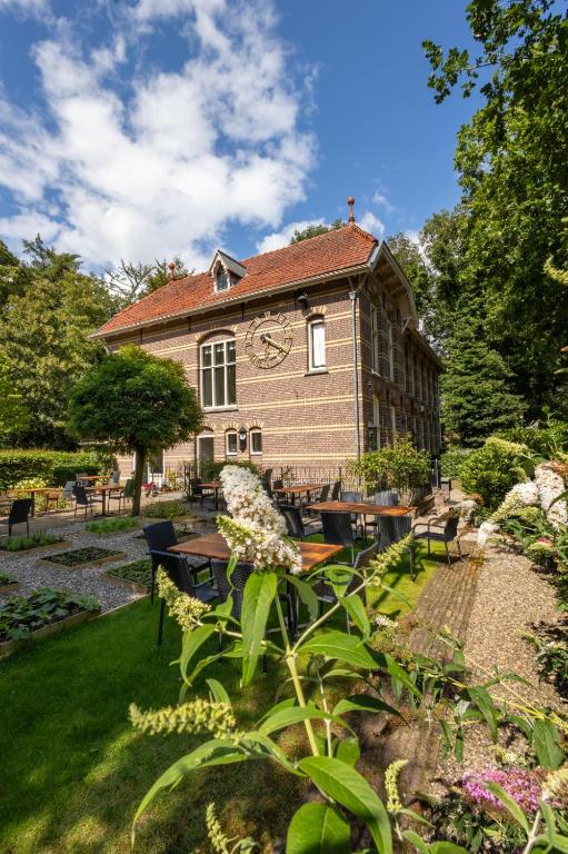 a building with a clock on the side of it at POSTEN nordic cuisine in Frederiksoord
