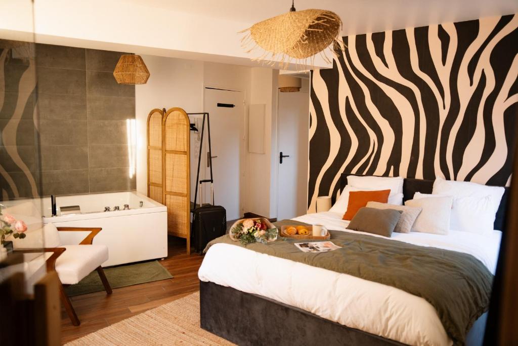 una camera da letto con un letto e un bagno con vasca di Suite Cara - Logement Atypique Sauna Balneo - Centre Historique a Brive-la-Gaillarde