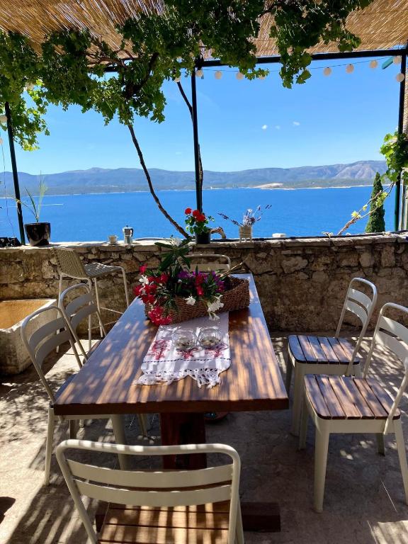 a wooden table and chairs with flowers on it at Blue Dream in Murvica