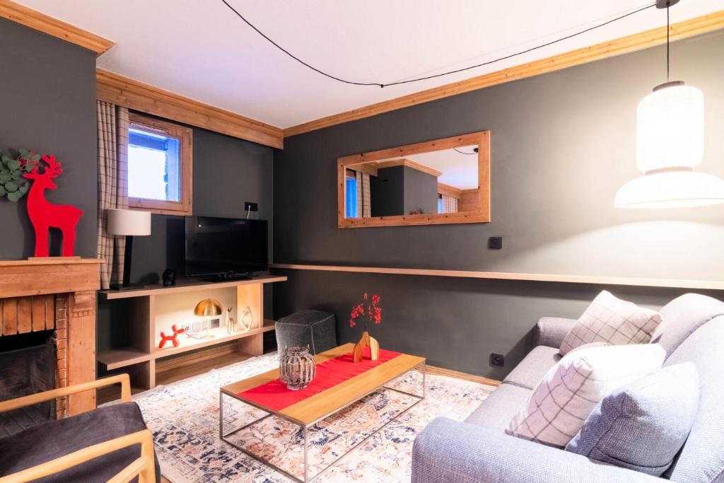 un salon avec un canapé et une cheminée dans l'établissement Chalet Mouflon - 4 Pièces pour 6 Personnes MAE-1821, à Val Thorens