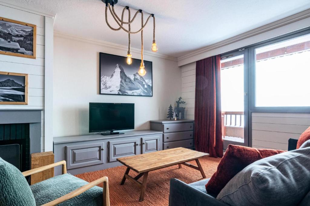 un salon avec un canapé et une télévision dans l'établissement Chalet Chamois - EN COMPLETE RENOVATION MAE-6351, à Val Thorens