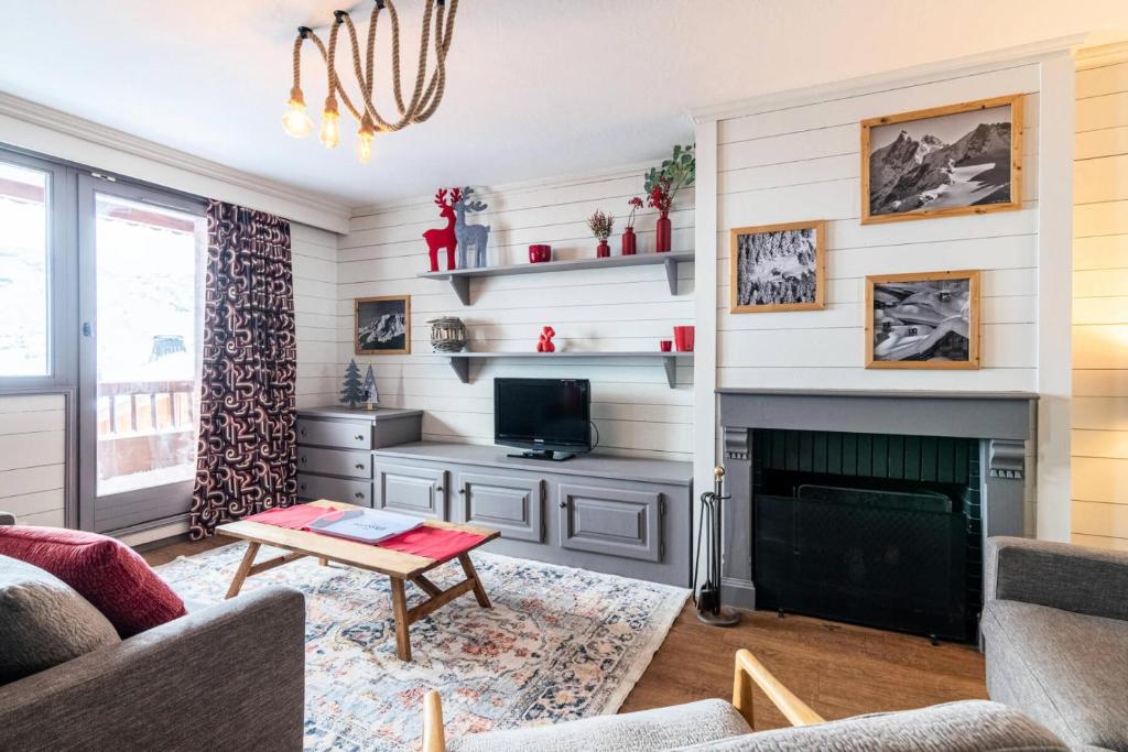 un salon avec une cheminée et une télévision dans l'établissement Chalet Chamois - EN COURS DE RENOVATION MAE-6341, à Val Thorens