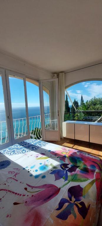 Un dormitorio con una cama con vista al mar. en Maison Patricia Menton Appartemets, en Menton