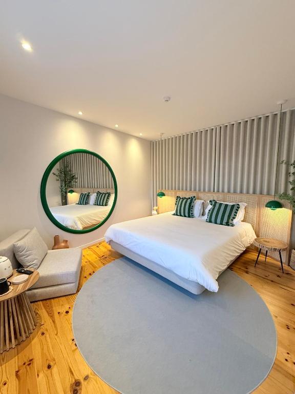 a bedroom with a large bed and a large mirror at O Laranjal in Guimarães