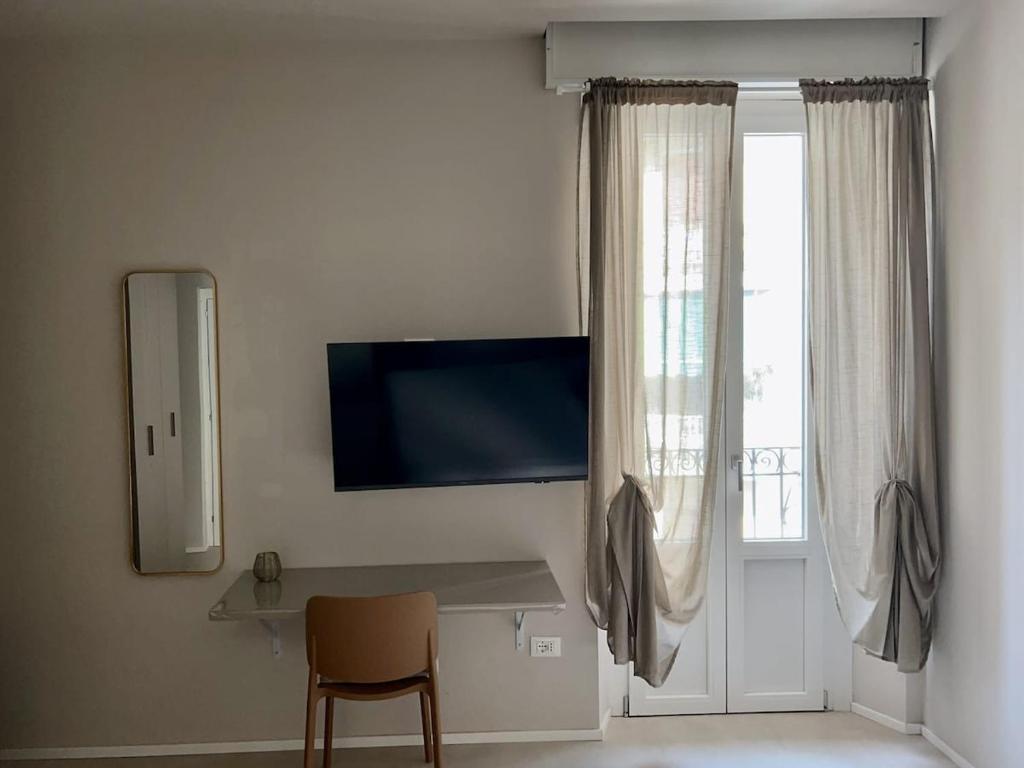 San Martino Suite - Pavia City - by HOST4U في بافيا: غرفة مع طاولة ومرآة ونافذة