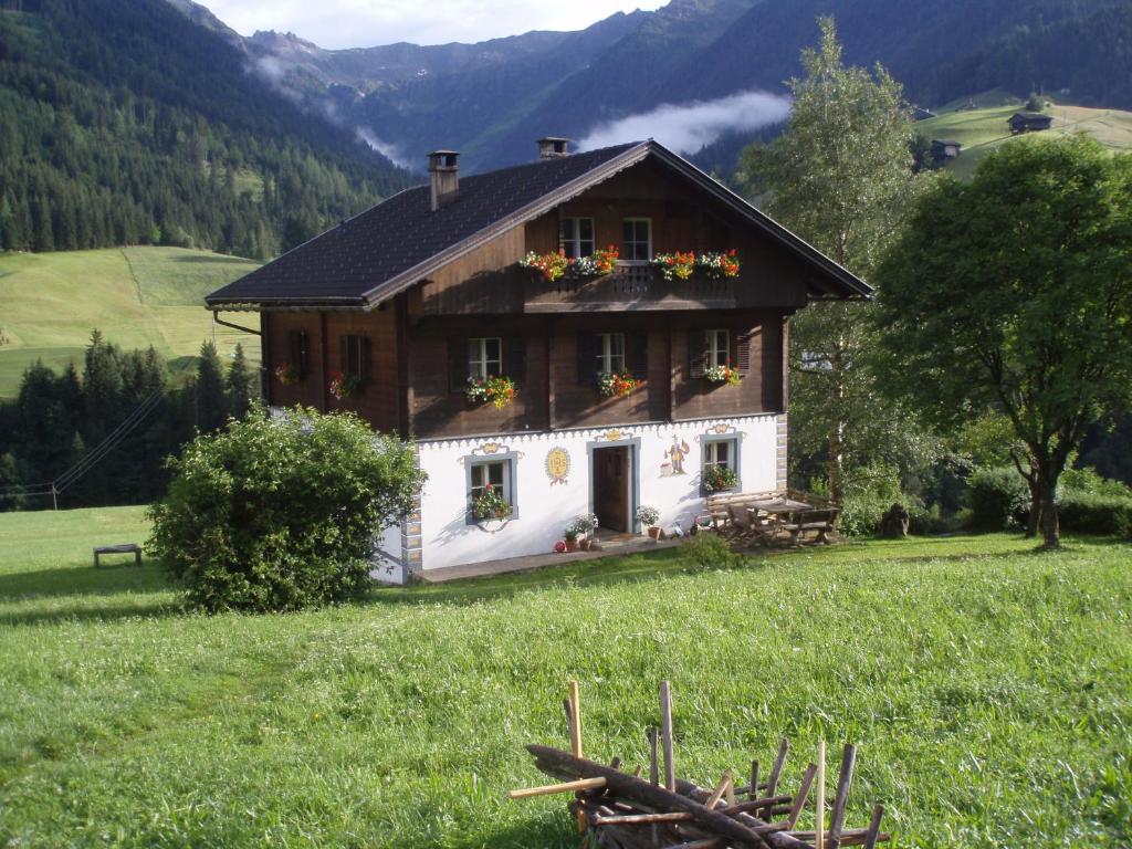a house in a field with flowers on it at Bauernhof im Wiesengrund in Maria Luggau