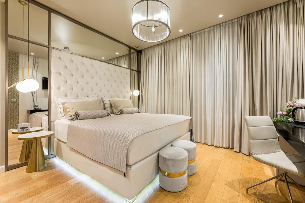 a bedroom with a large white bed and a desk at Luxury Rooms Fortuna in Split