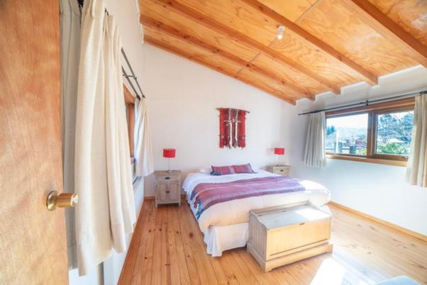 a bedroom with a bed and a wooden ceiling at Cabañas Neyén in Malalcahuello
